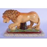 A CONTINENTAL POTTERY FIGURE OF A ROAMING LION modelled upon a rectangular base. 18 cm wide.