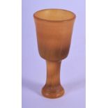 A 19TH CENTURY GERMAN CARVED RHINOCEROS HORN GOBLET of miniature form with tapering shaft. 11 grams.