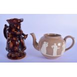 AN EARLY 19TH CENTURY ENGLISH TREACLE GLAZED POTTERY CHARACTER JUG together with a salt glazed teapo