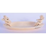 A VERY UNUSUAL EARLY 20TH CENTURY SWISS CARVED IVORY BOAT modelled with opposing putti. 13 cm x 6 cm