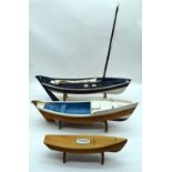 Two hand made wooden models of Fishing smacks together with a clinker built money box boat. 51cm (3)