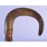 A 19TH CENTURY MIDDLE EASTERN CARVED RHINOCEROS HORN HANDLED WALKING CANE. 86 cm long.