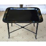 AN ANTIQUE PAPIER MACHE TRAY upon a bamboo type ebonised stand. 77 cm x 50 cm.