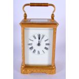 AN ANTIQUE BRASS ENGRAVED CARRIAGE CLOCK decorated with foliage. 18 cm high inc handle.