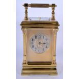 AN ANTIQUE BRASS REPEATING CARRIAGE CLOCK with column supports. 20.5 cm high inc handle.