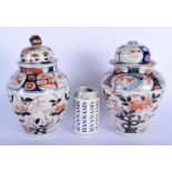 A PAIR OF 18TH CENTURY JAPANESE EDO PERIOD IMARI VASES AND COVERS painted with floral sprays. 27 cm