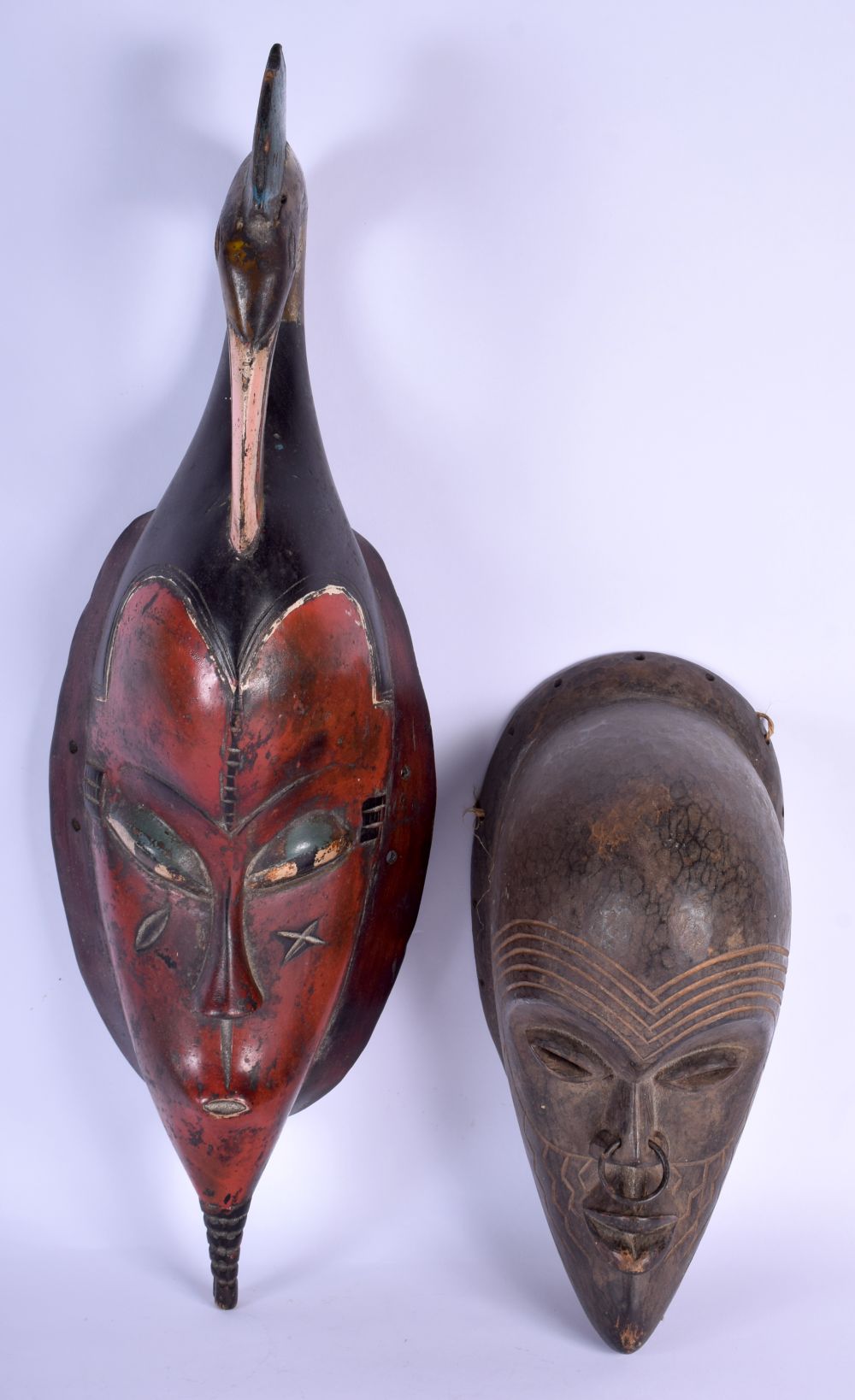 AN AFRICAN TRIBAL IVORY COAST GURO MASK together with another tribal hardwood mask. Largest 60 cm lo