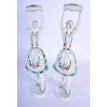 A LARGE PAIR OF HUNGARIAN HOLLOHAZA PORCELAIN FIGURES modelled as females holding pillows. 30 cm hig