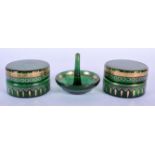 TWO ANTIQUE GREEN GLASS BOXES with matching ring holder. 6.75 cm diameter. (3)