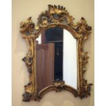 AN ANTIQUE CONTINENTAL GILTWOOD SCROLLING MIRROR with acanthus capped banding. 70 cm x 60 cm.