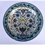 AN EARLY MIDDLE EASTERN FAIENCE IZNIK GLAZED POTTERY DISH painted with floral sprays. 27 cm diameter