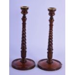 A PAIR OF ANTIQUE TURNED WOOD CANDLESTICKS. 36 cm high.