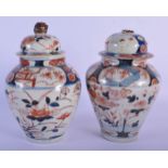 A PAIR OF 18TH CENTURY JAPANESE EDO PERIOD IMARI VASES AND COVERS painted with floral sprays. 27 cm