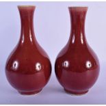 A MATCHED PAIR OF 19TH CENTURY CHINESE SANG DU BOEUF PORCELAIN VASES Qing, of bulbous form. 24.5 cm