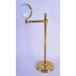 A STYLISH EARLY 20TH CENTURY BRASS MAGNIFYING LENS upon a sliding body. 36 cm high.