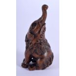 A JAPANESE TAISHO PERIOD CARVED WOOD NETSUKE modelled as a mythical beast. 5.75 cm high.