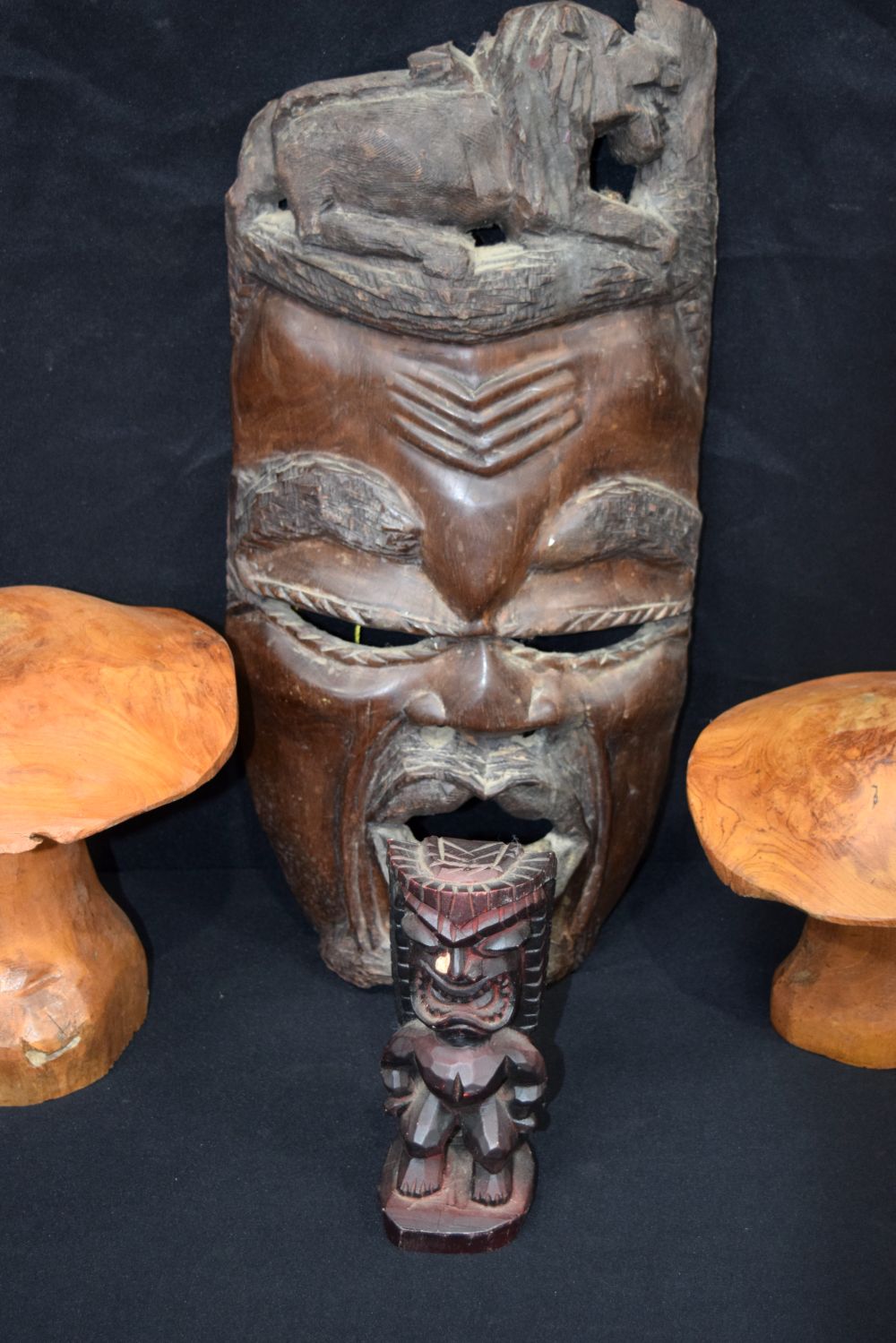 A large carved hardwood African mask, together with two carved wooden mushrooms and a small wooden t - Image 3 of 9