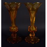 A PAIR OF 19TH CENTURY BOHEMIAN AMBER GLASS VASES. 21 cm high.