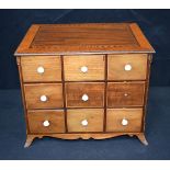 A small antique wooden inlaid storage cabinet with nine drawers . 28 x 35 x 27cm.