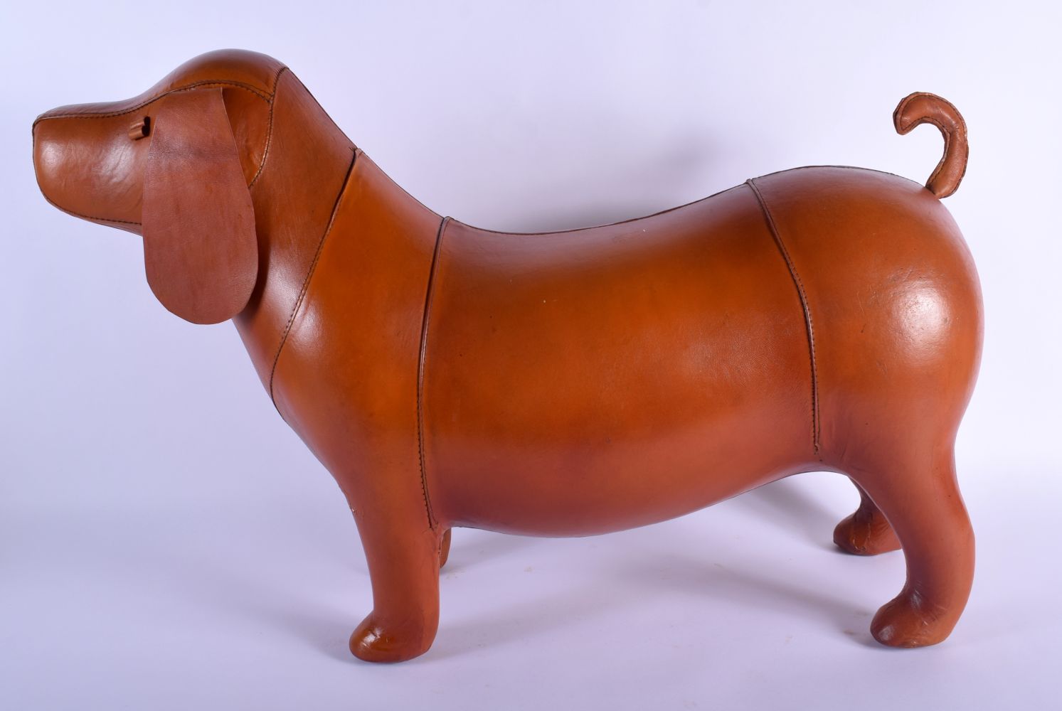 A CONTEMPORARY BROWN LEATHER DOG. 70 cm x 36 cm.