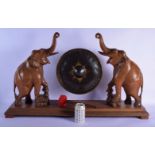 A LARGE EARLY 20TH CENTURY INDIAN CARVED HARDWOOD HANGING GONG formed with two elephants upon natura