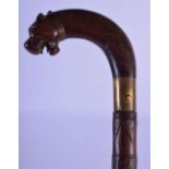 A RARE MID 19TH CENTURY COLONIAL ANGLO INDIAN CARVED HARDWOOD SWORD STICK formed as a scowling beast