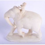 A LATE 19TH CENTURY INDIAN CARVED MARBLE FIGURE OF A ROAMING ELEPHANT modelled with an attendant upo