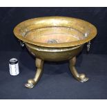 A large vintage hammered brass twin handled bowl set on dolphin head legs 36 x 52cm.