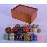 A COLLECTION OF 19TH CENTURY CARVED HARDSTONE SPECIMEN EGGS within a mahogany box. Largest 4 cm x 3
