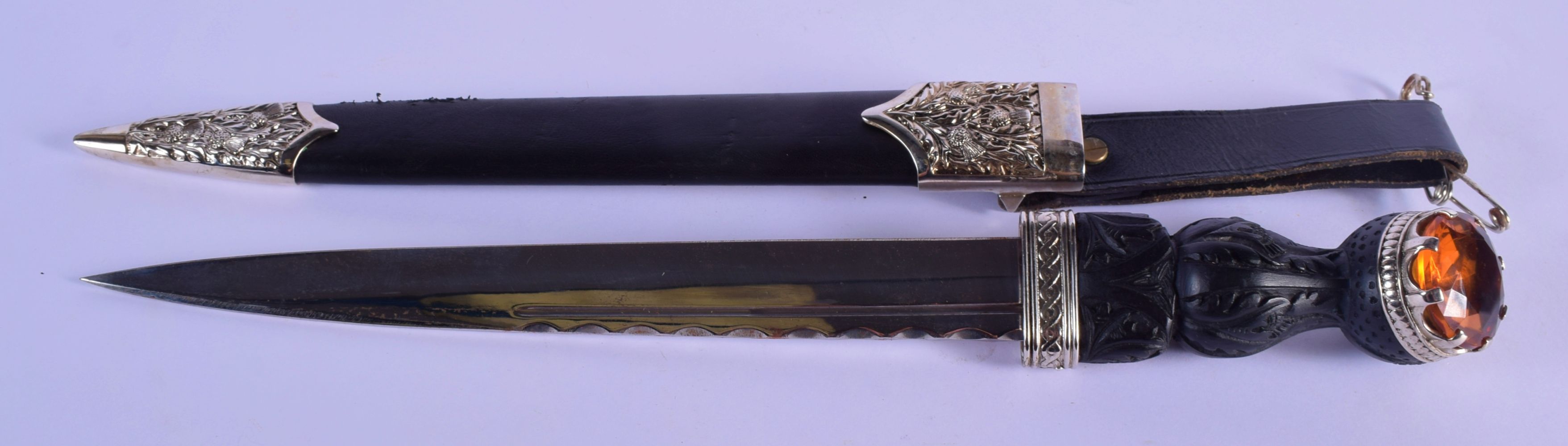 A SCOTTISH WHITE METAL MOUNTED CITRINE DIRK DAGGER with thistle overlaid leather scabbard. 44 cm lon