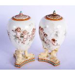 A PAIR OF 19TH CENTURY WEDGWOOD VASES AND COVERS painted with putti. 21.5 cm high.