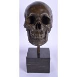 A CONTEMPORARY BRONZE SCULPTURE OF A SKULL upon a marble plinth. 37 cm high.