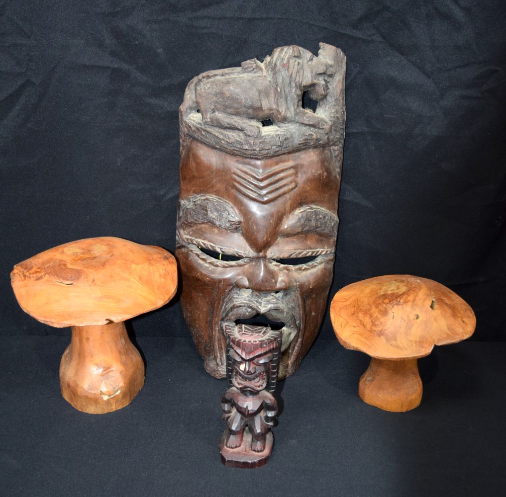 A large carved hardwood African mask, together with two carved wooden mushrooms and a small wooden t