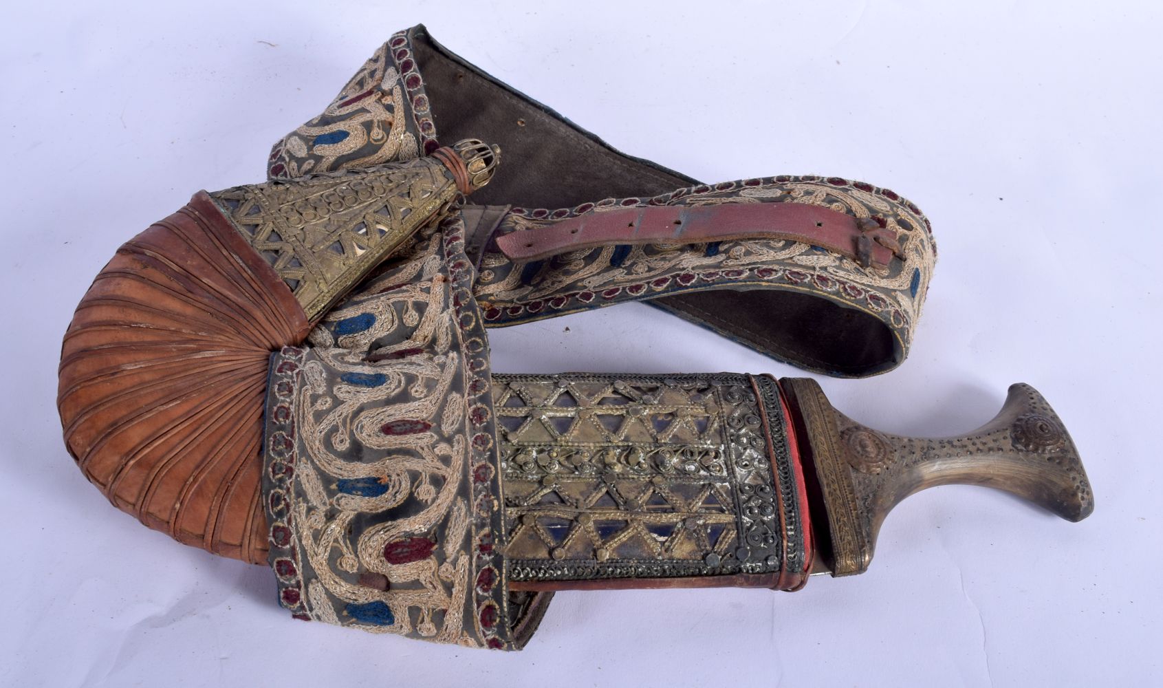 A 19TH CENTURY MIDDLE EASTERN CARVED RHINOCEROS HORN HANDLED JAMBIYA DAGGER overlaid with a silk sca