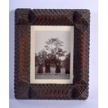 A TRENCH ART PHOTOGRAPH FRAME decorated with monks in a landscape. 18 cm x 14 cm.