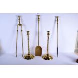 A SET OF VINTAGE BRASS FIRESIDE IRONS and a large pair of candlesticks. Longest 66 cm long. (5)