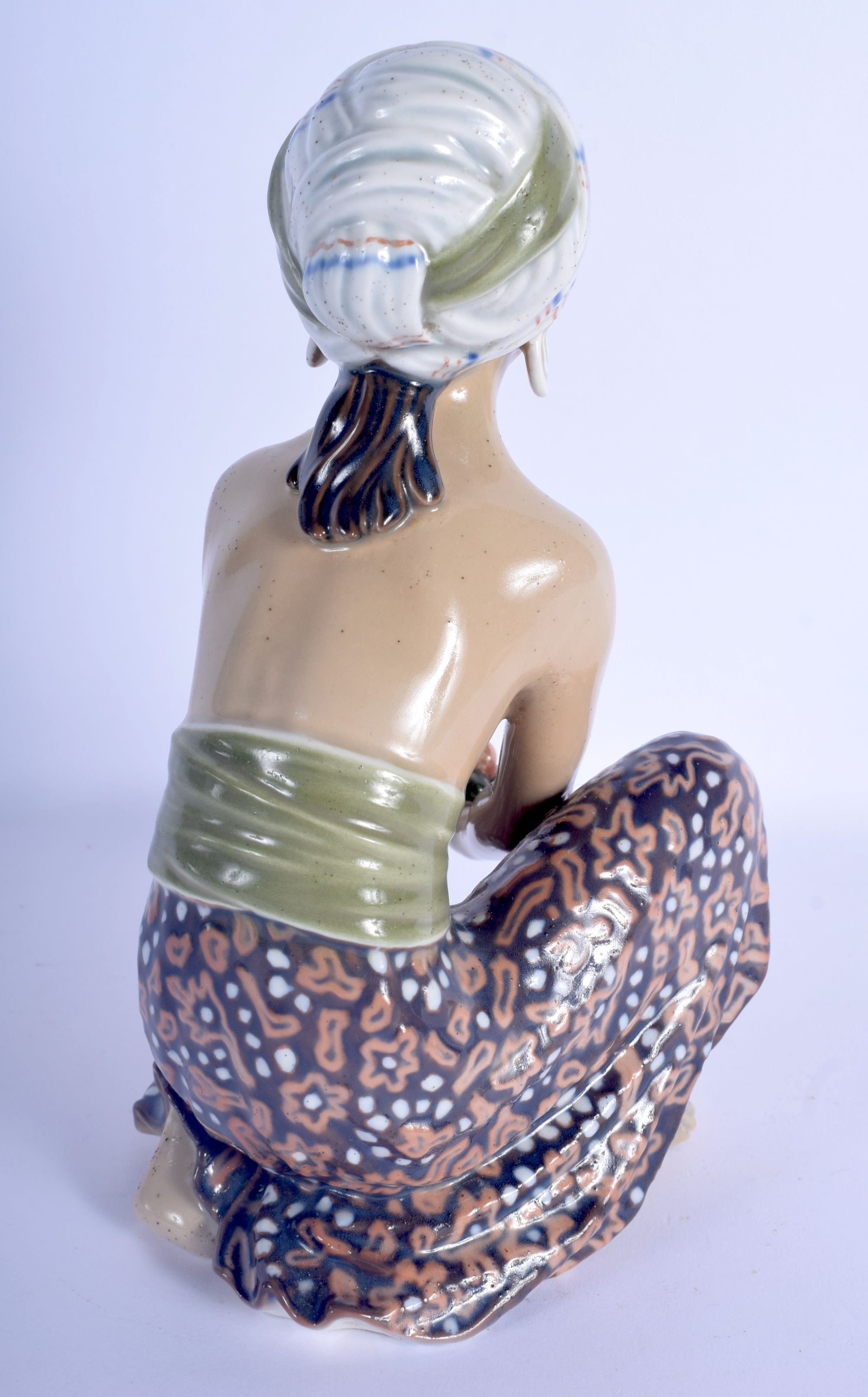 AN UNUSUAL EARLY 20TH CENTURY EUROPEAN POTTERY FIGURE OF A FEMALE modelled holding a fruiting pod. 2 - Image 2 of 3