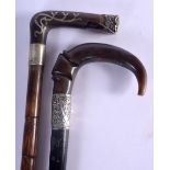TWO 19TH CENTURY CONTINENTAL CARVED RHINOCEROS HORN HANDLED WALKING CANES one with silver mounts. 90
