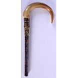 A 19TH CENTURY CONTINENTAL CARVED RHINOCEROS HORN PARASOL HANDLE with bamboo shaft. 22 cm long.