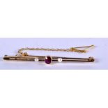 A GOLD BAR BROOCH WITH A GARNET AND PEARLS. 5.8cm long, weight 3.63g