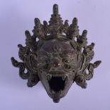 AN 18TH/19TH CENTURY TIBETAN BRONZE MASK HEAD BRUSH WASHER modelled scowling. 11 cm x 11 cm.