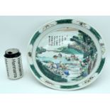 A large Chinese porcelain Famille-Verte dish decorated with figures in a landscape and calligraphy.