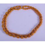 AN ART DECO HONEY AMBER TYPE BEAD NECKLACE. 128 cm long.