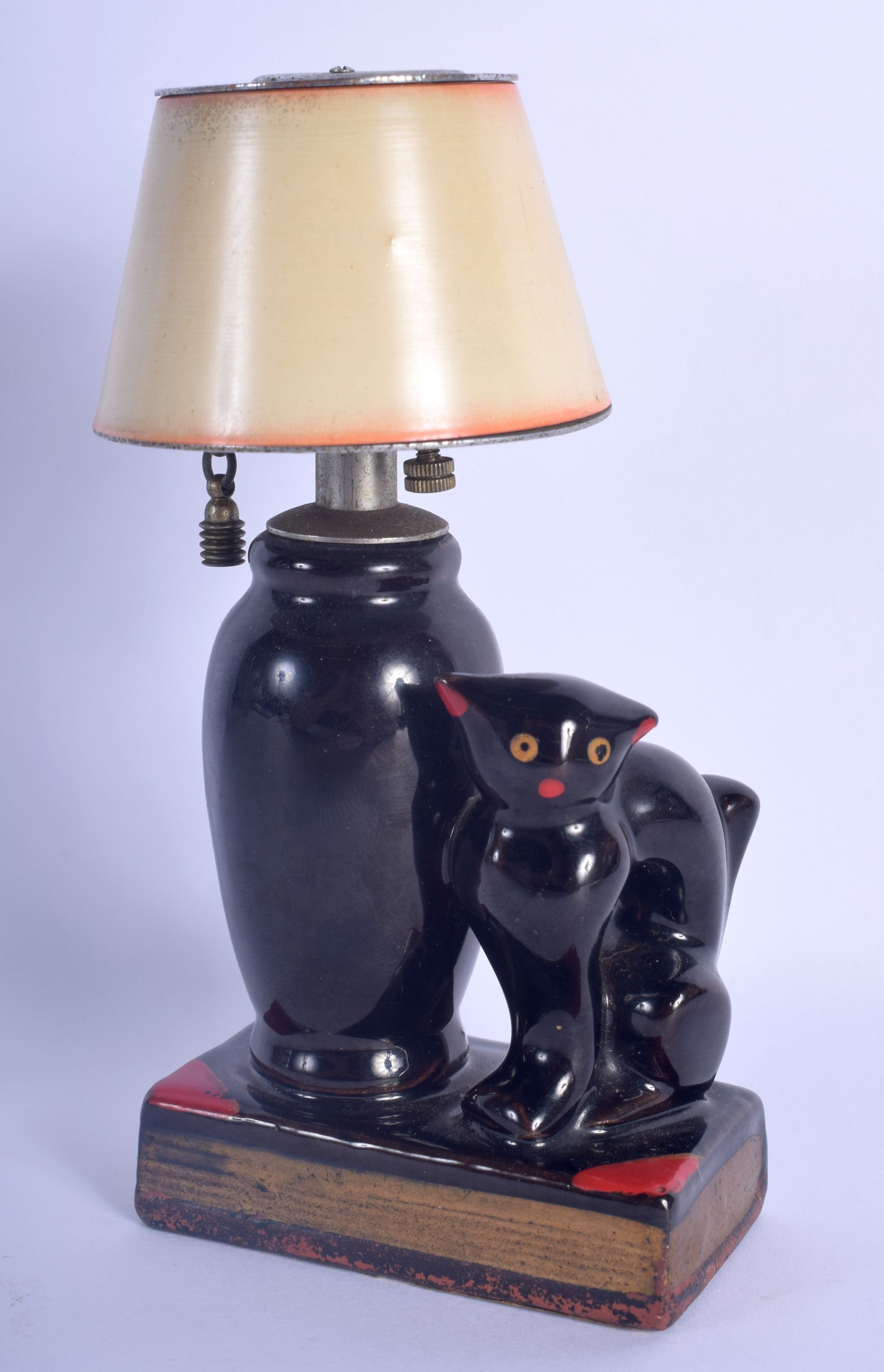 A RARE VINTAGE EVANUS POTTERY CAT TABLE LIGHTER modelled beside a lamp. 14 cm x 7 cm.