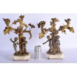 A PAIR OF 19TH CENTURY FRENCH GILT BRONZE AND ORMOLU CANDLEABRA modelled as putti playing instrument