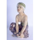 AN UNUSUAL EARLY 20TH CENTURY EUROPEAN POTTERY FIGURE OF A FEMALE modelled holding a fruiting pod. 2