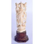 A 19TH CENTURY ANGLO INDIAN CARVED IVORY FIGURE OF A BUDDHISTIC DEITY modelled upon a carved wood ba