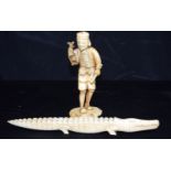 A Japanese ivory figure of a male holding a rat, together with an ivory crocodile. Largest 25cm. (2)