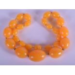 A VINTAGE AMBER TYPE NECKLACE. 45 cm long, largest bead 3 cm x 1.75 cm.