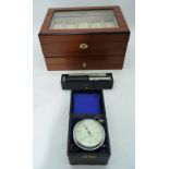 An Axis lockable watch case together with an Otis Kings calculator and a boxed vintage gauge.
